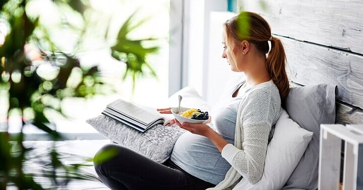Pregnant woman with bowl of fruit