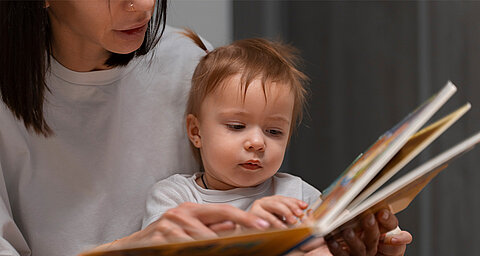 Mum reading a book to her baby