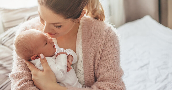 Mum cuddling newborn baby