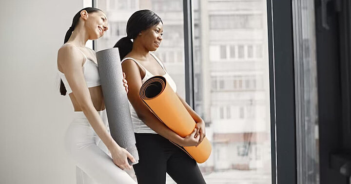 Two women preparing for a pilates class