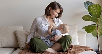 Mum breastfeeding baby in bed