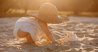 Baby on beach in hat