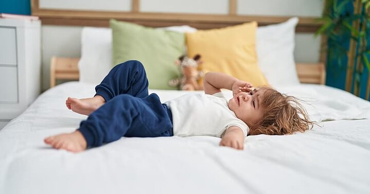 Toddler throwing tantrum on bed