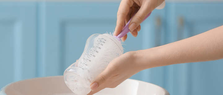 Washing up baby bottle in sink