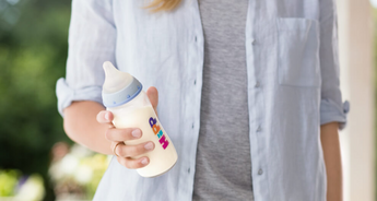 Woman holding HiPP baby bottle