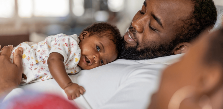 Dad lying on sofa with baby on chest