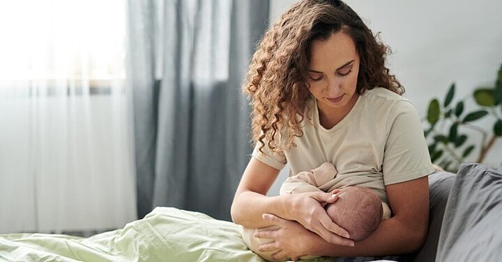 Mum breastfeeding baby in bed