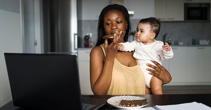 Mum eating with baby on hip