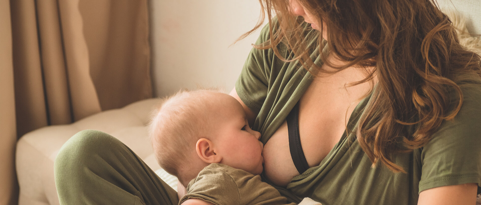 woman in green top breastfeeding baby