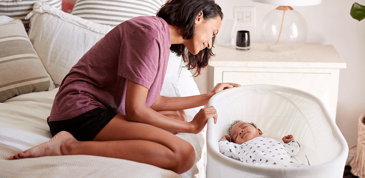 Mum checking on newborn in crib