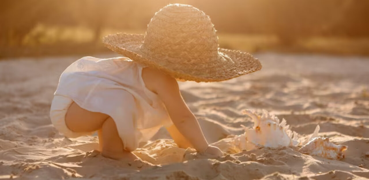 Baby on beach in hat