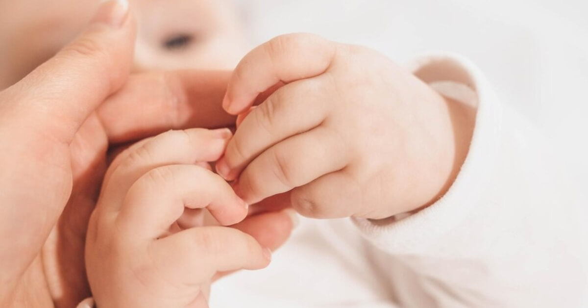 baby holding parents fingers