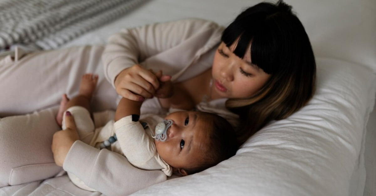 Mum and baby cuddling in bed