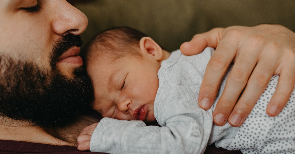 Dad holding sleeping baby